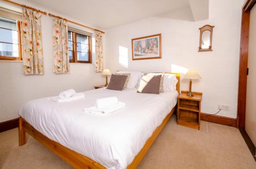 a bedroom with a large white bed in a room at Bens Cottage in Chapel Stile