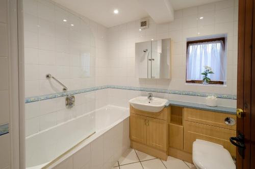 a bathroom with a tub and a sink and a toilet at Bens Cottage in Chapel Stile