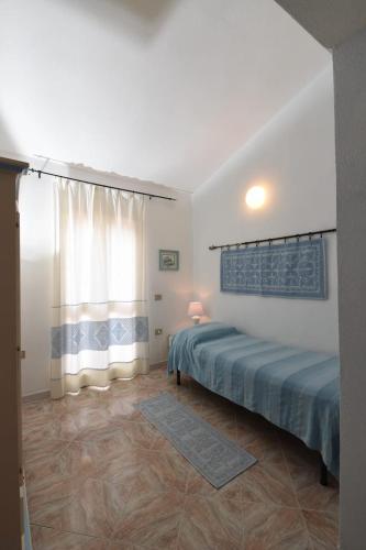 馬達萊納的住宿－Villetta a schiera，一间卧室设有一张床和一个窗口