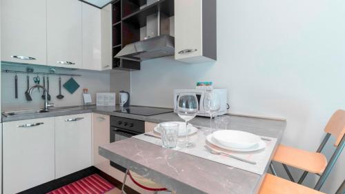 uma cozinha com uma mesa com copos de vinho em Italianway - Zuretti 32 em Milão