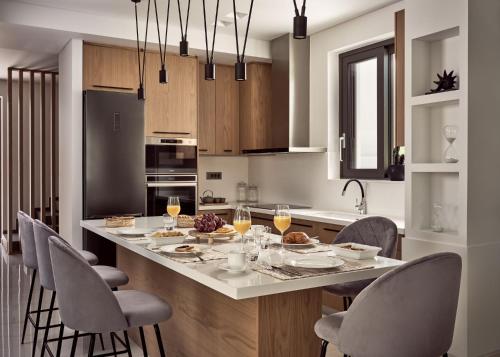 uma cozinha com uma grande ilha com uma mesa com cadeiras em Anthis Luxury Villa em Zakynthos Town