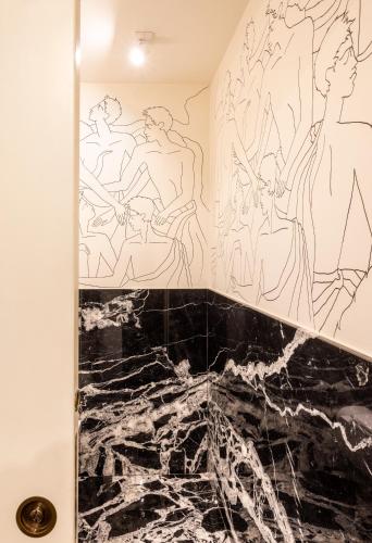 a bathroom with black and white drawings on the wall at Nerva Boutique Hotel in Rome