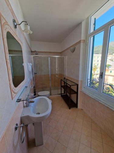 ein Bad mit einem Waschbecken und einem Spiegel in der Unterkunft Hotel Miramare in Spotorno