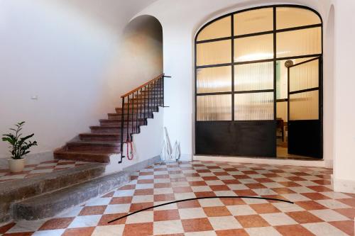 an emptyoyer with a staircase and a checkerboard floor at La casa di Chele in Palermo