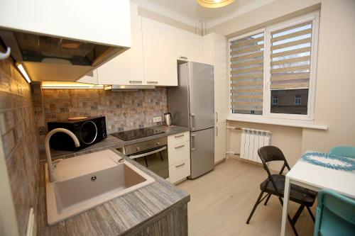 a kitchen with a sink and a refrigerator at Cathedral Apartments in Vilnius