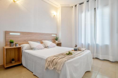 ラ・ピネーダにあるAlea Rentals - Turquesaの白いベッドルーム(白いシーツを使用した大型ベッド1台付)