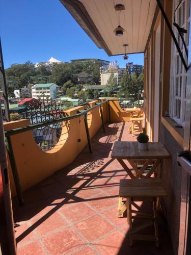 a balcony with a table and bench on a building at Casa Generosa in Baguio