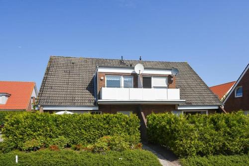 a house with a white balcony on top of it at Ferienwohnung Stern in Bensersiel