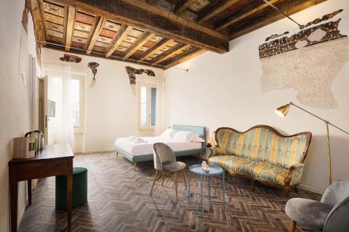 1 dormitorio con 1 cama y 1 sofá en Residenza Giulio Romano en Mantova