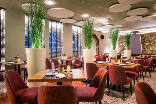 a restaurant with tables and chairs and potted plants at Hotel Vorfelder in Walldorf