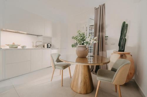 een keuken met een tafel en twee stoelen en een cactus bij Palazzo Natoli Boutique Hotel in Palermo