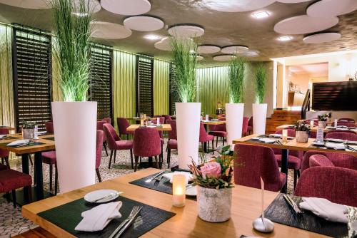 a restaurant with tables and chairs and plants on the ceilings at Hotel Vorfelder in Walldorf