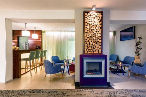 a living room with a fireplace and a bar at Hotel Vorfelder in Walldorf