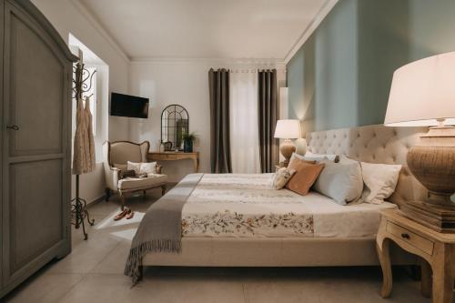 a bedroom with a large bed and a chair at Palazzo Natoli Boutique Hotel in Palermo