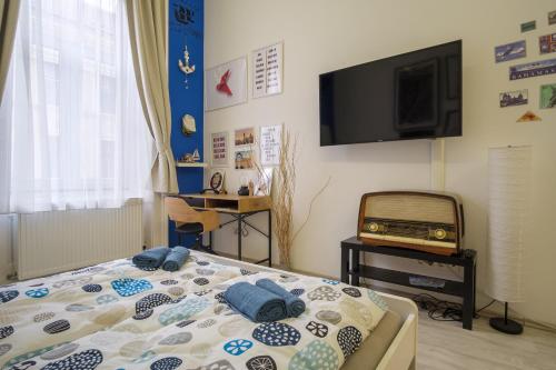 een slaapkamer met een bed en een flatscreen-tv bij Király88 Apartment in Boedapest