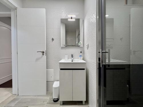 a white bathroom with a sink and a shower at Vilamoura Marina Mar 2 With Pool by Homing in Vilamoura