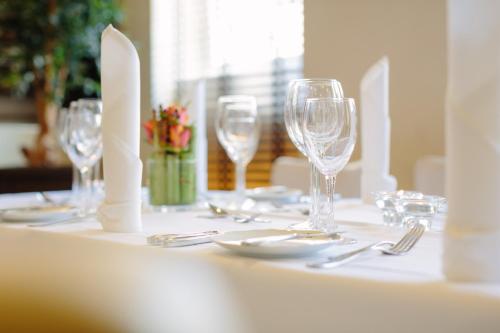 a table with wine glasses and silverware on it at Hotel Vorfelder in Walldorf