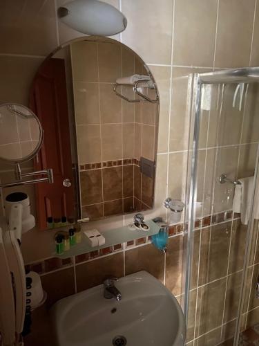 a bathroom with a sink and a shower with a mirror at STELLA HOTEL&Spa ALL INCLUSIVE in Kemer