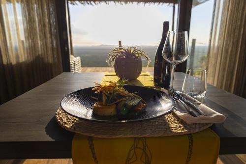 a plate of food on a table with a window at TimBila Safari Lodge in Omaruru