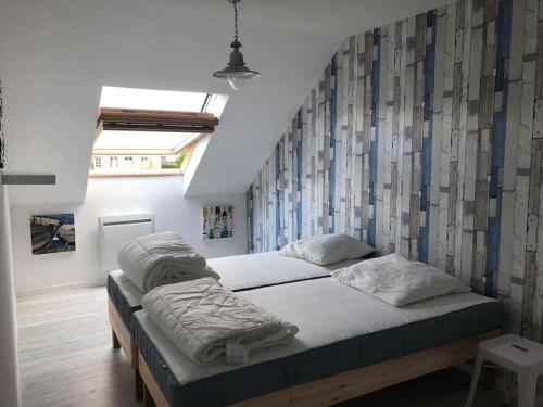- un grand lit dans une chambre avec un mur dans l'établissement Duplex Normandie, tout confort Saint Valery en Caux, à Saint-Valery-en-Caux