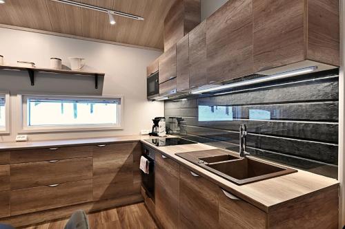 cocina con armarios de madera, fregadero y ventana en Economy Autto, en Levi