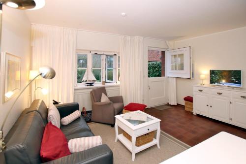 un soggiorno con divano e tavolo di Ohl Doerp 22 Pastoratshof_ Haus 3 a Wrixum