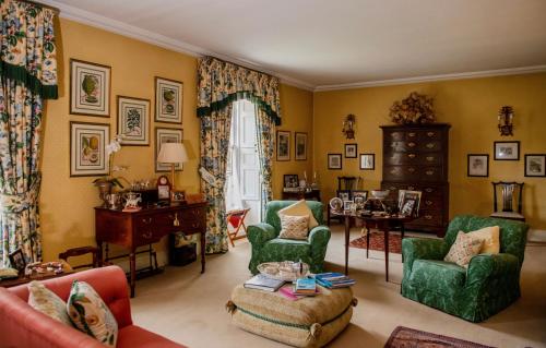 a living room with green chairs and a table at Ballymote Country House in Downpatrick
