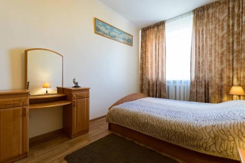 a bedroom with a bed and a mirror and a window at Nadezhda Apartments in Samal in Almaty