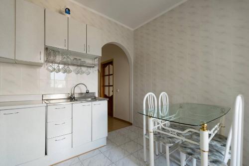 a kitchen with a sink and a glass table at Nadezhda Apartments in Samal in Almaty