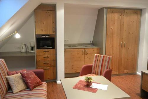 a kitchen and a living room with a couch and a table at Hotel Zum Löwen - Unteres Wirtshaus in Titisee-Neustadt