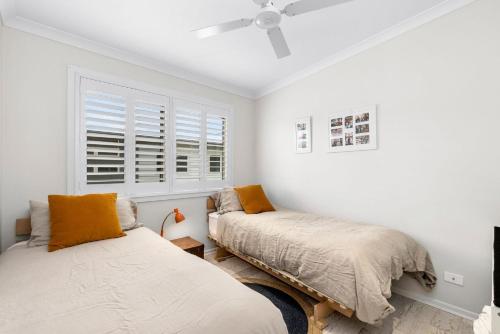 a bedroom with two beds and a ceiling fan at Alice's Palace, 2-minute walk to lifeguard patrolled surf beach in Ocean Grove