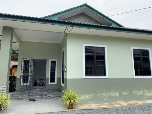a small white house with a porch at Homestay Cikgu Fatiah in Kota Bharu