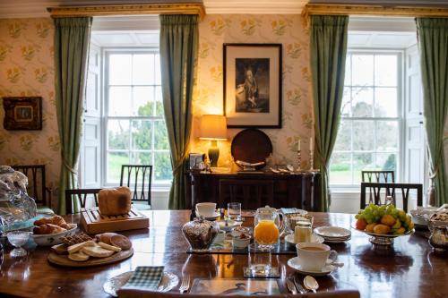una sala da pranzo con tavolo e cibo di Ballymote Country House a Downpatrick
