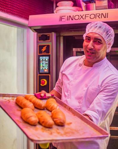 a chef holding a tray of hot dogs at Playa Palmera Beach Resort in Punta Cana
