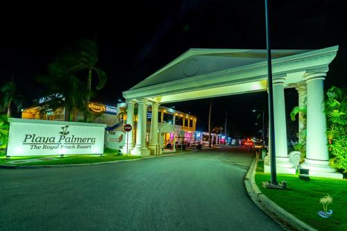a building with a sign on the side of a street at Playa Palmera Beach Resort in Punta Cana