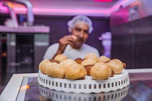 a man standing behind a table with a plate of donuts at Playa Palmera Beach Resort in Punta Cana
