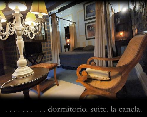 a living room with a chair and a table with a lamp at Casona Camino Real De Selores in Selores