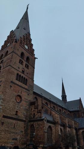 a large brick building with a clock tower at Rosdala gård - gästhuset in Rydsgård