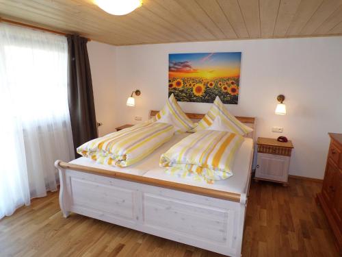 ein Schlafzimmer mit einem Bett mit gelben und weißen Kissen in der Unterkunft Landhaus Müller in Bad Birnbach