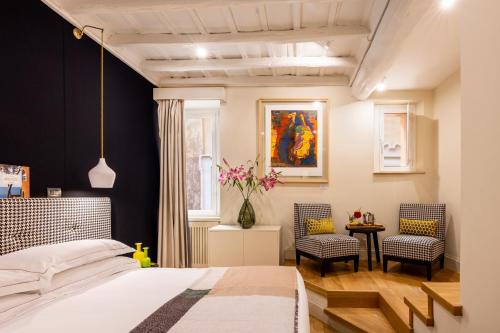 ローマにあるネルヴァ ブティック ホテルのベッドルーム1室(ベッド1台、椅子2脚付)