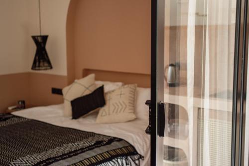 una camera da letto con letto, lenzuola e cuscini bianchi di Black Honey ad Ahangama