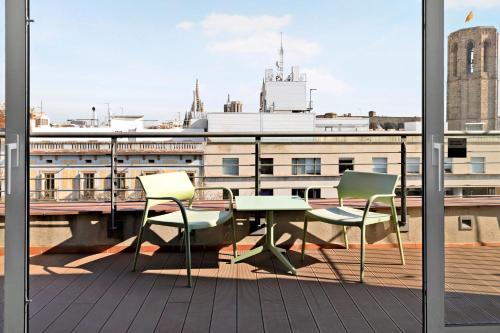 einen Balkon mit einem Tisch und Stühlen auf einem Gebäude in der Unterkunft numa I Boqueria Apartments in Barcelona