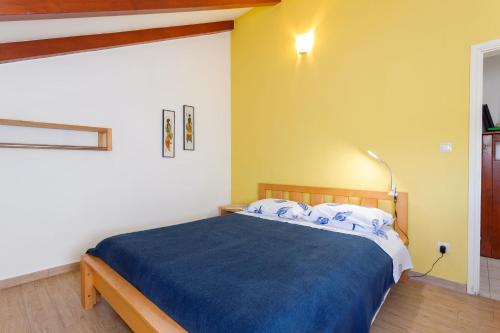 een slaapkamer met een bed met een blauwe deken bij House Ivo in Stomorska