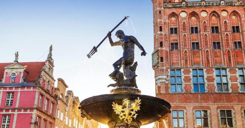 a statue of a man with a cross on a fountain at Słoneczny apartament z ogródkiem in Gdańsk