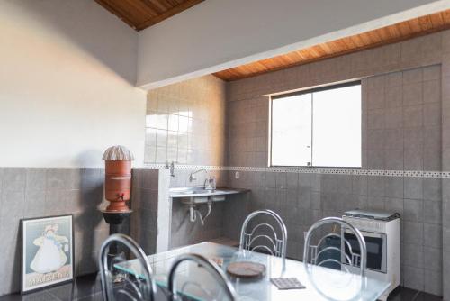 a dining room with a glass table and chairs at Suítes em Casa Duplex no Pontal in Ilhéus