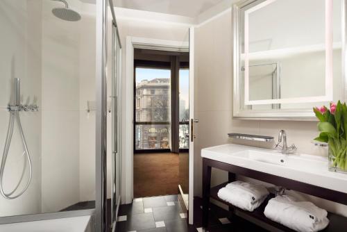 a bathroom with a sink and a shower at UNAHOTELS Cusani Milano in Milan
