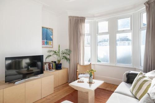 een woonkamer met een bank en een tv bij Relax in Stunning House in Great Central Location in Cardiff