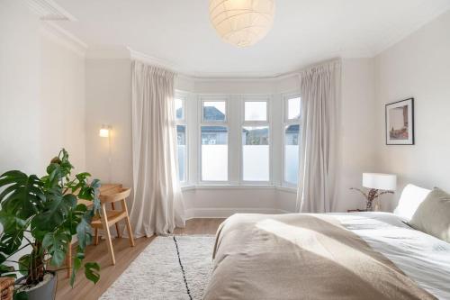 1 dormitorio con cama y ventana grande en Relax in Stunning House in Great Central Location, en Cardiff