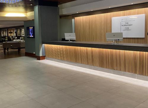 a hotel lobby with a reception counter and a desk at Normandy Hotel (Near Glasgow Airport) in Paisley