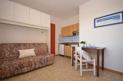 ビビオーネにあるAppartamenti I Moschettieriのリビングルーム(ソファ、テーブル付)、キッチンが備わります。